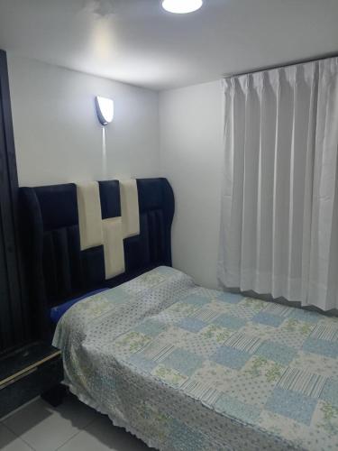 a bedroom with a bed with a cross on it at Dpto Amoblado ILO-PERU in Ilo