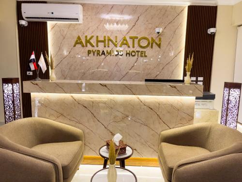 a lobby with two chairs and a marble wall at AKHNATON Pyramids View Hotel With Rooftop Access & free airport pickup in Cairo