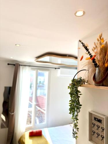 a kitchen with a window and a clock on a wall at Studio confort proche de aéroport Paris-Orly in Villeneuve-le-Roi