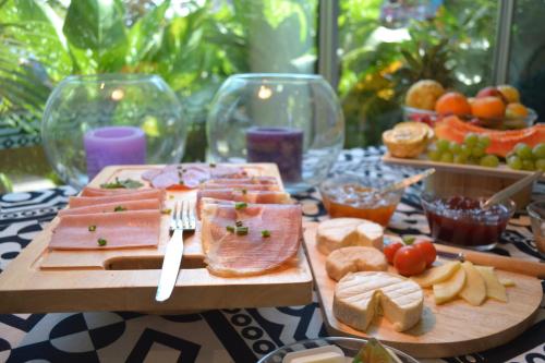 a table topped with cheese and meats on cutting boards at Art House in Luanda