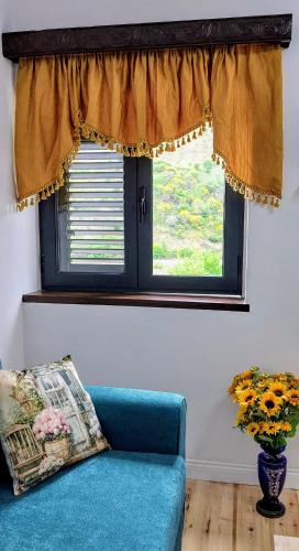 a blue couch in a living room with a window at Sweet Home Aria in Çorovodë