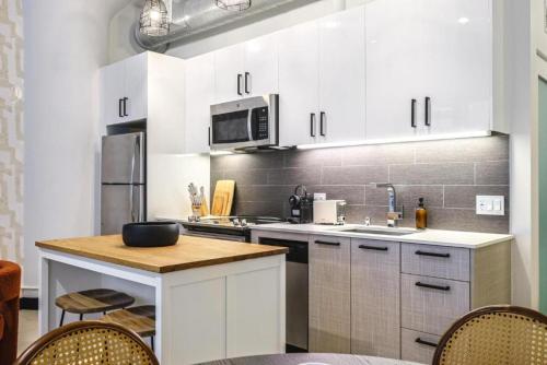 a kitchen with white cabinets and a counter top at Stunning 1 BDR 1 BTH Modern Loft with Pool, Jacuzzi in DTLA! in Los Angeles