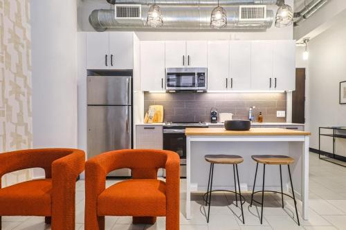 a kitchen with two bar stools and a counter top at Stunning 1 BDR 1 BTH Modern Loft with Pool, Jacuzzi in DTLA! in Los Angeles