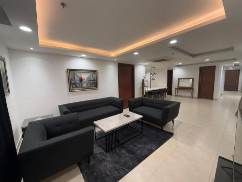 a living room with two couches and a table at Luxury Apartments at Goldcrest Mall and Residency DHA Phase 4 by Nirvana Nests in Lahore