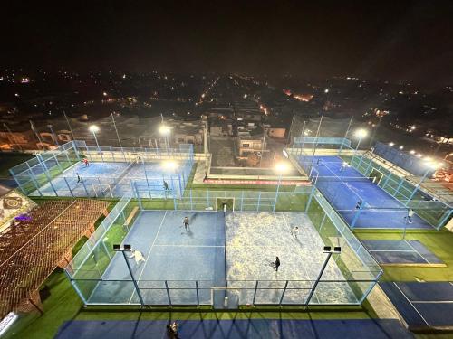an overhead view of three tennis courts at night at Luxury Apartments at Goldcrest Mall and Residency DHA Phase 4 by Nirvana Nests in Lahore