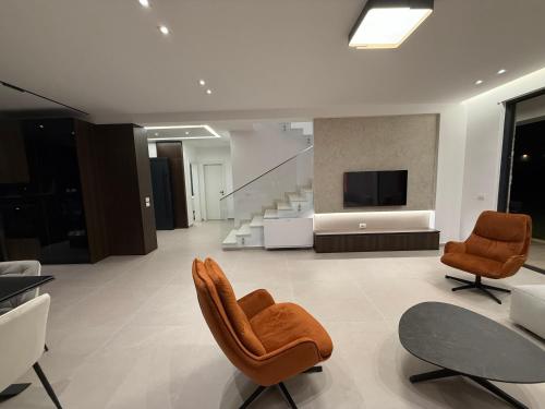 a living room with two chairs and a television at BelVilla in Lalzit Bay