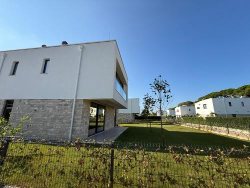 a building with a fence in front of a yard at BelVilla in Lalzit Bay