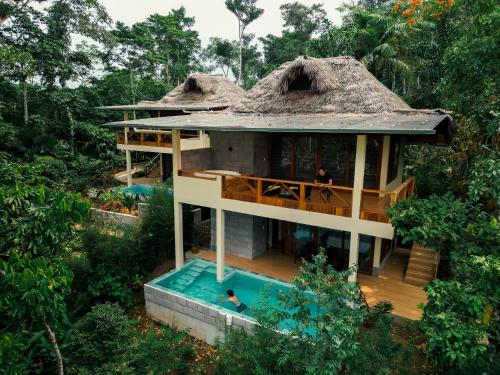 an aerial view of a house with a thatched roof at El Jardin Lodge & Spa in Puerto Misahuallí