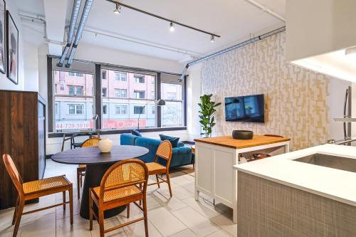 a kitchen and living room with a table and chairs at Stunning 1 BDR 1 BTH Modern Loft with Pool, Jacuzzi in DTLA! in Los Angeles