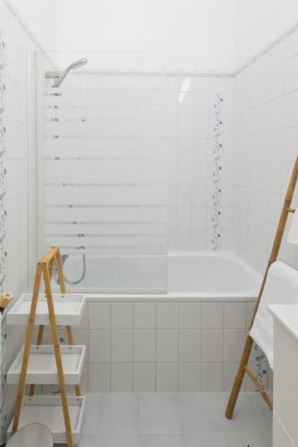 a white bathroom with a tub and a ladder at Le Rétro - Hyper Centre - Balcon et terrasse in Tarbes