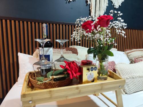 einen Tisch mit zwei Weingläsern und Blumen darauf in der Unterkunft Romántico Glamping tipo contenedor con Jacuzzi cerca al lago de Paipa in Paipa