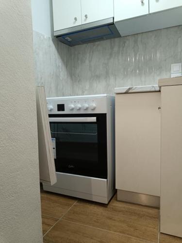 a kitchen with a stove and white cabinets at LA CASA Di GIORGIO in Pentati