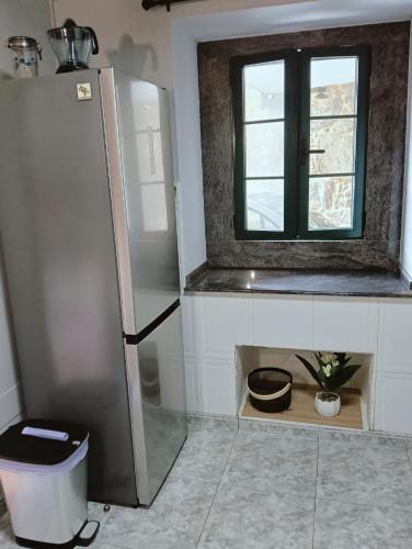 a kitchen with a refrigerator and a window at Casa Consuelo in Sabardes