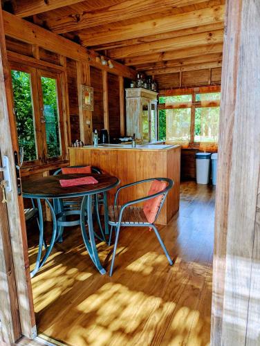 a dining room with a table in a cabin at RAIATEA - The BEACH HOUSE - plage sur le lagon ! in Tevaitoa