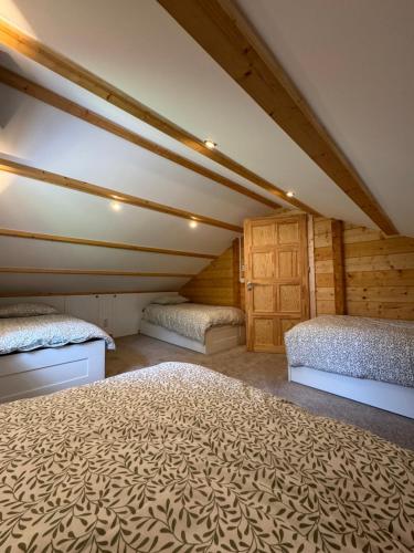 1 dormitorio en el ático con 2 camas y armarios de madera en Huize Eléna, en Lochem