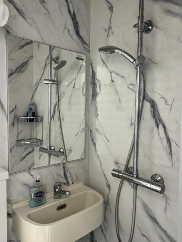 a bathroom with a sink and a shower and a mirror at Motel Schmotel in Brighton & Hove