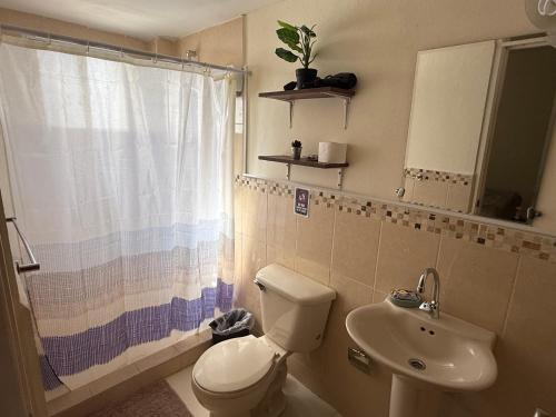 a bathroom with a toilet and a sink at Hacienda Apartments near the beach in Oranjestad