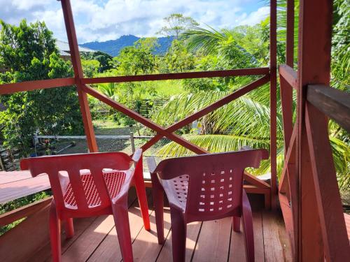 two chairs and a table on a wooden porch at Cabaña Pichindé in Estación El Salto