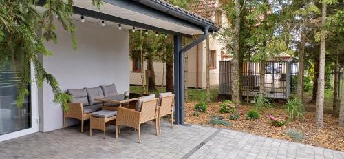 a patio with a table and chairs on a patio at Apartamenty Nadmorskie lofty in Gąski