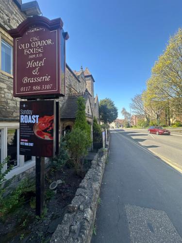 a sign for a restaurant on the side of a street at The Old Manor House Hotel in Keynsham