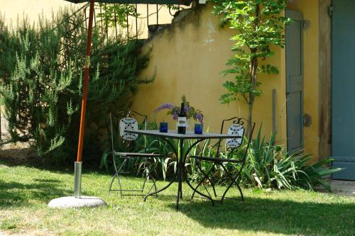 a table with two chairs and an umbrella in the grass at Tenuta Il Tresto in Poggibonsi