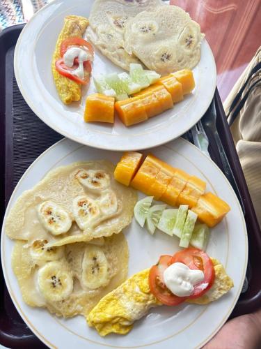 two plates of food on a tray with breakfast foods at Renata Cottages in Ohoililir