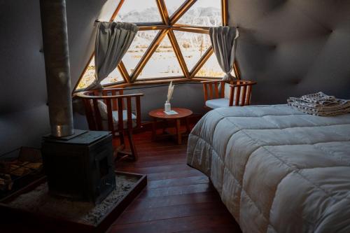 a bedroom with a bed and a large window at Domo La Isla in Tilcara