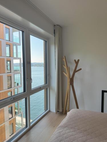 a bedroom with a large window overlooking the water at Casa Cimili City in Kristiansand