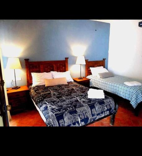 a bedroom with two beds and two lamps on tables at Casa de Campo luciérnaga in San Miguel de Allende