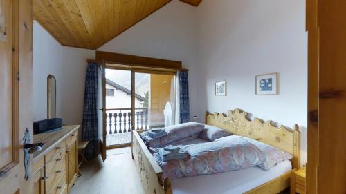 a bedroom with a bed with a dresser and a window at Carla 12 in Sils Maria