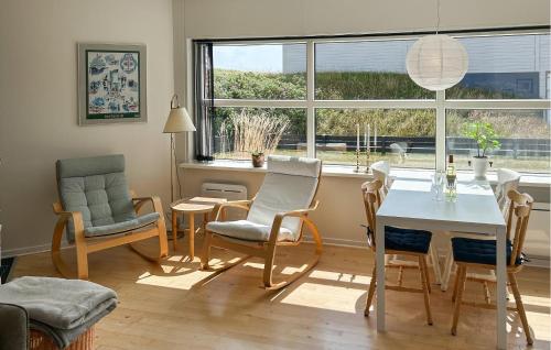 un soggiorno con tavolo, sedie e una finestra di 2 Bedroom Stunning Apartment In Fanø a Fanø