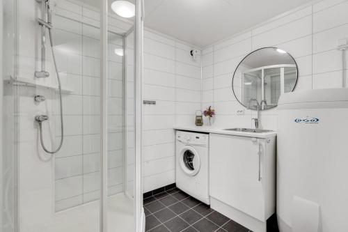 baño blanco con lavadora y espejo en Nice apartment on Futrikelva, en Tromsø