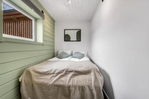 Una cama pequeña en una habitación con ventana. en Nice apartment on Futrikelva, en Tromsø