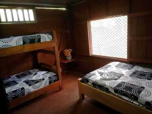 a bedroom with two bunk beds and a window at Cabaña Pichindé in Estación El Salto