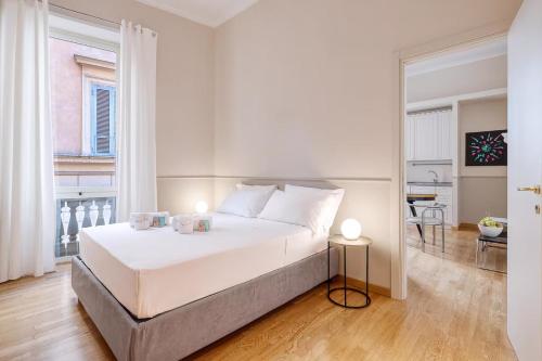 a bedroom with a large white bed and a table at Navona Boutique House in Rome