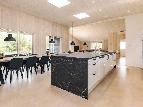 a kitchen and dining room with a large island with black marble at 5 star holiday home in Højslev in Højslev