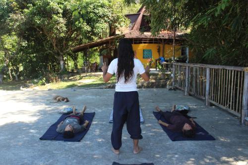 a woman standing in front of three people laying on mats at Rancho de la luna in Minca