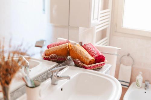 a bathroom counter with a sink and towels in baskets at Al Civico Centocinquantasei in Latiano
