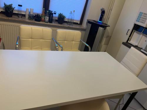 a white table and chairs in a room at Monteurzimmer mit Küchennutzung in Bad Essen