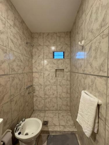 een badkamer met een wastafel, een toilet en een douche bij Temporal Colonia Caroya in Colonia Caroya