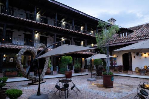 a courtyard with tables and umbrellas in a building at HOTEL PLAZA SAN CRISTOBAL INN in San Cristóbal de Las Casas