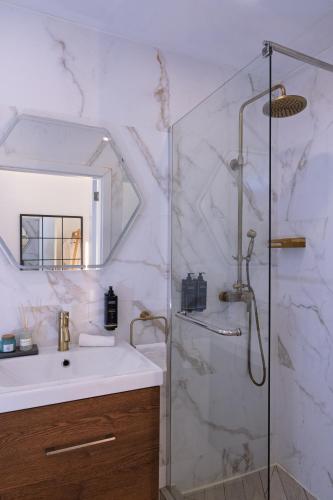 a bathroom with a shower and a sink and a mirror at Alvor Serene House I in Alvor