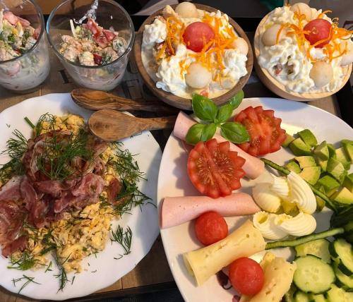 a wooden table with plates of food on it at Bio-Nestlein Apartments in Löffingen