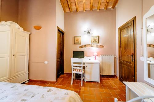 a bedroom with a bed and a desk with a computer at Bio Agriturismo Il Melograno di Banditella Ristorante in Alberese