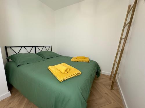 a bed with two yellow towels sitting on top of it at La Casa Carnon - Sur le Port - Moderne & Lumineux in Mauguio