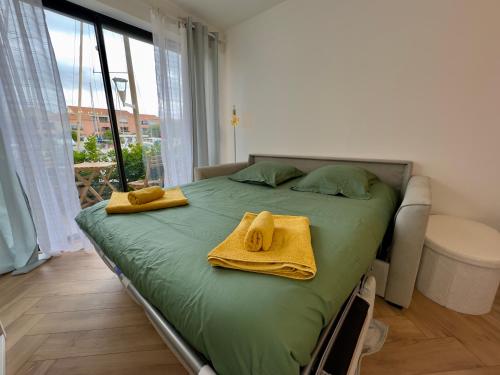 a bedroom with a bed with towels on it at La Casa Carnon - Sur le Port - Moderne & Lumineux in Mauguio