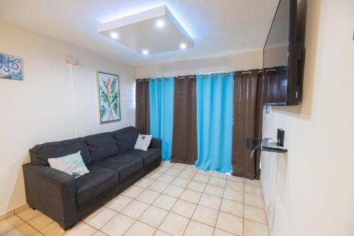 a living room with a couch and blue curtains at Beach Apartment C3 Montones in Jobos