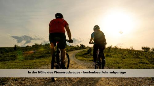 two people riding bikes down a dirt road at Colleen Apartments - Minden, Hermannstraße in Minden