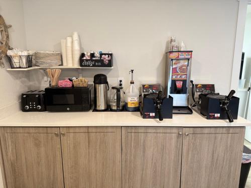 a kitchen counter with a microwave and appliances on it at West Beach Suites in Lincoln City