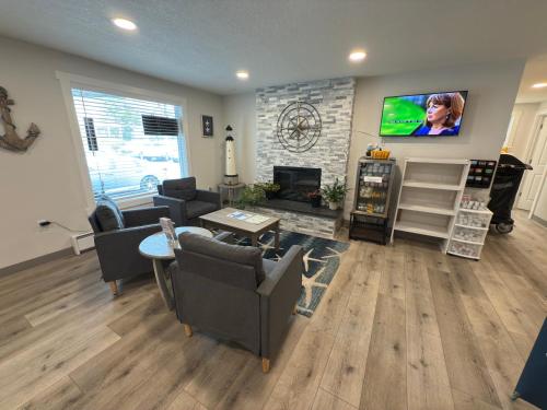 a living room with a fireplace and a tv at West Beach Suites in Lincoln City